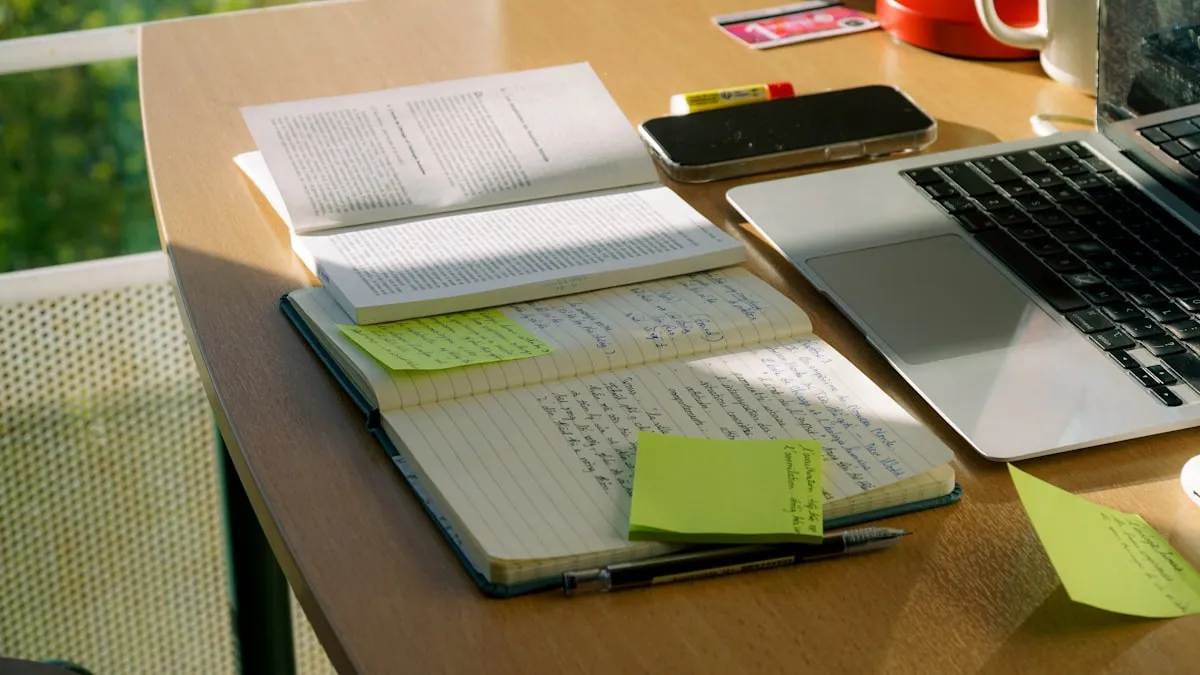 Laptop and handwritten notes on a sunlit desk